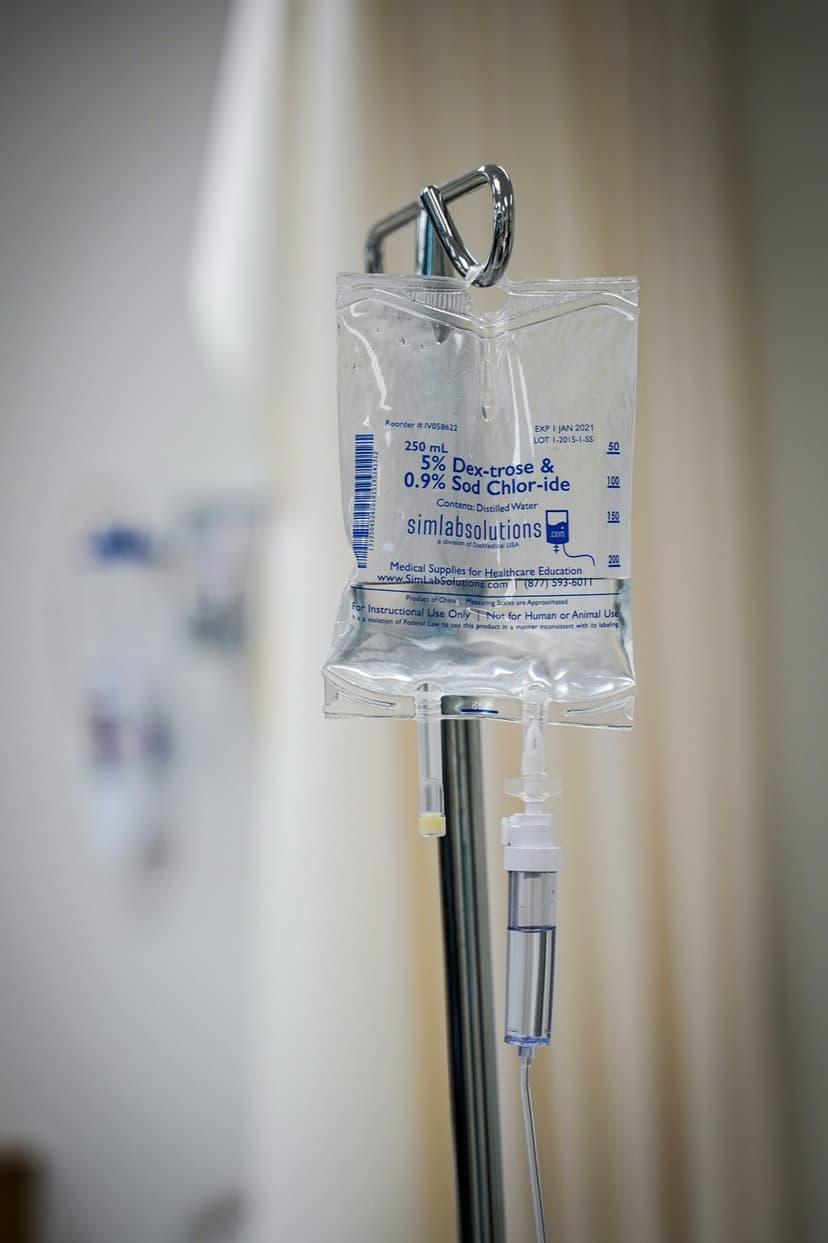 En intravenös dropppåse hänger på ett droppställ i ett sjukhusrum