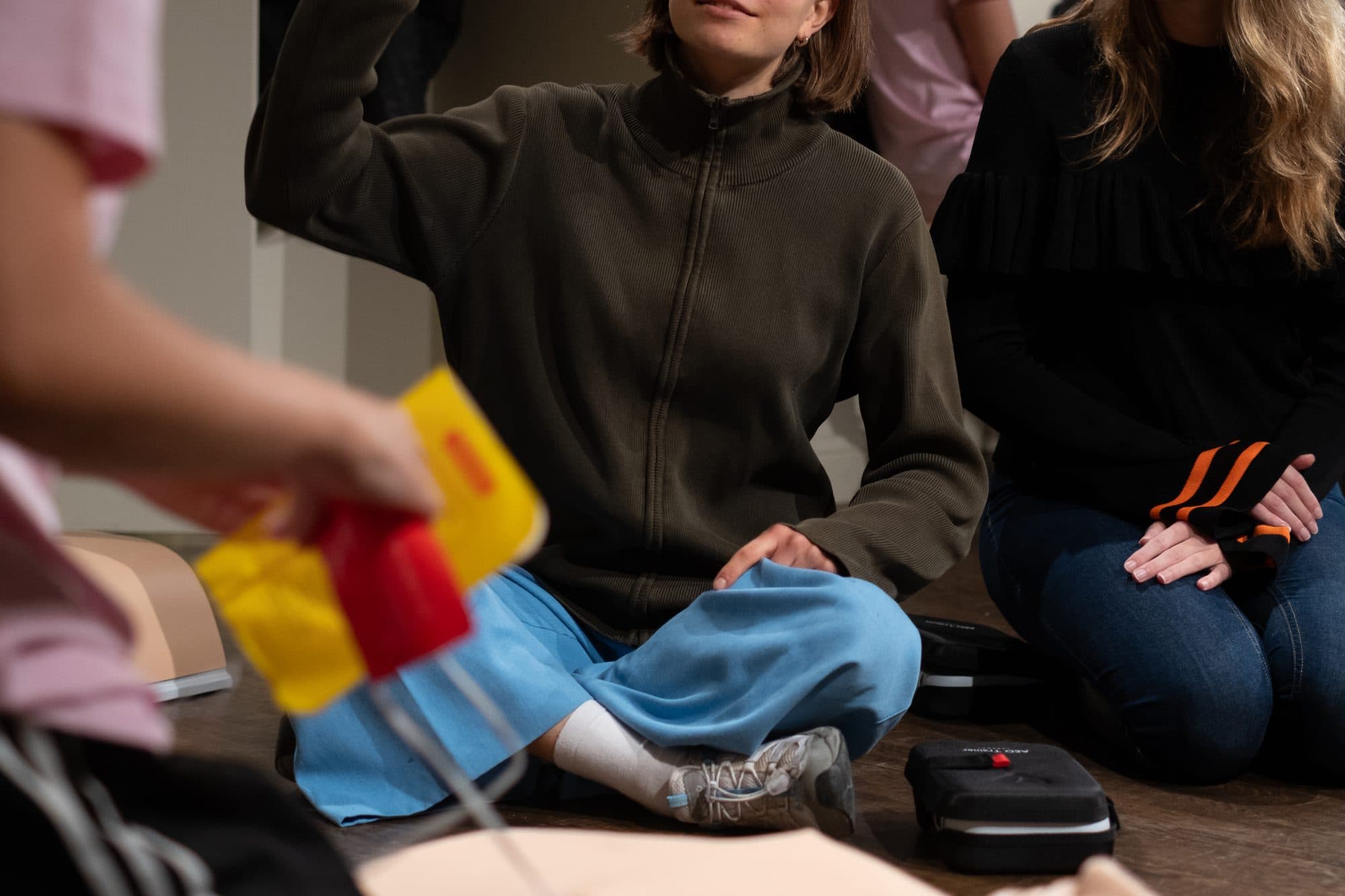 Gula träningselektroder i en hand under en HLR-kurs