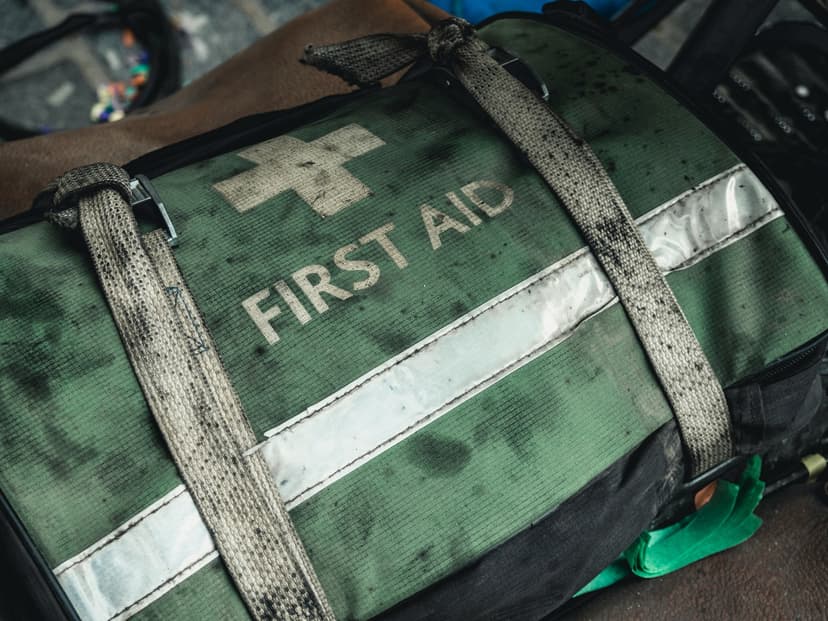 Närbild på en sliten grön väska med texten First Aid